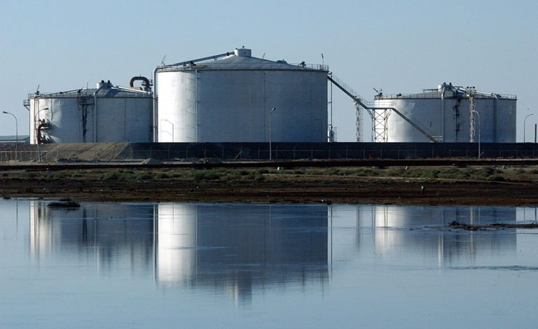 CENTRAL KUWAIT - JANUARY 13: Kuwaiti oil production tanks are reflected in a lake of spilled oil at the Burgan oil field January 13, 2003 in Central Kuwait. The oil field, the largest in the world, was targeted by retreating Iraqi troops in 1991 in a scorched earth campaign ordered by Iraqi president Saddam Hussein. Today most of the facilities at Burgan have been rebuilt and it supplies more than 1.4 million barrrels of oil per day for export. (Photo by Scott Nelson/Getty Images)
