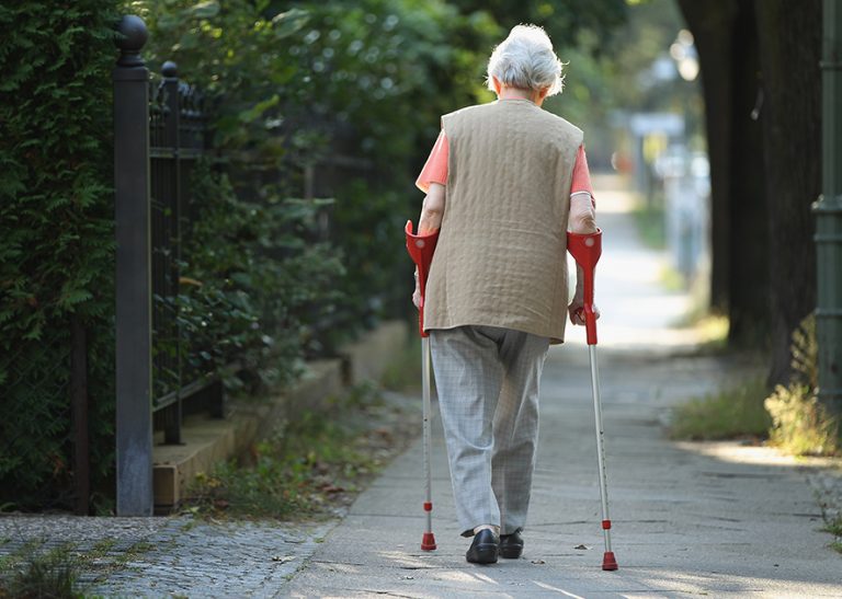 BERLIN, GERMANY - SEPTEMBER 18: An elderly woman walks with crutches on September 18, 2012 in Berlin, Germany. Germany is facing multiple problems stemming from an increase in the elderly proportion of its population, including increasing health care costs, strains on its social security system, a shortage of senior care workers and challenges to its labor market. (Photo by Sean Gallup/Getty Images)