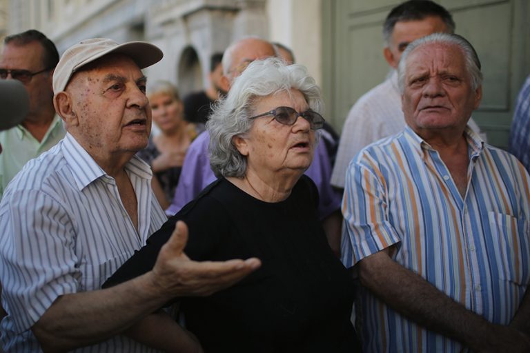ATHENS, GREECE - JULY 07: Senior citizens talk to bank staff as they queue up to collect their pensions outside a National Bank of Greece branch in Kotzia Square on July 7, 2015 in Athens, Greece. Greek Prime Minister Alexis Tsipras is working on new debt crisis proposals and is due to present them at a Eurozone emergency summit today. (Photo by Christopher Furlong/Getty Images)
